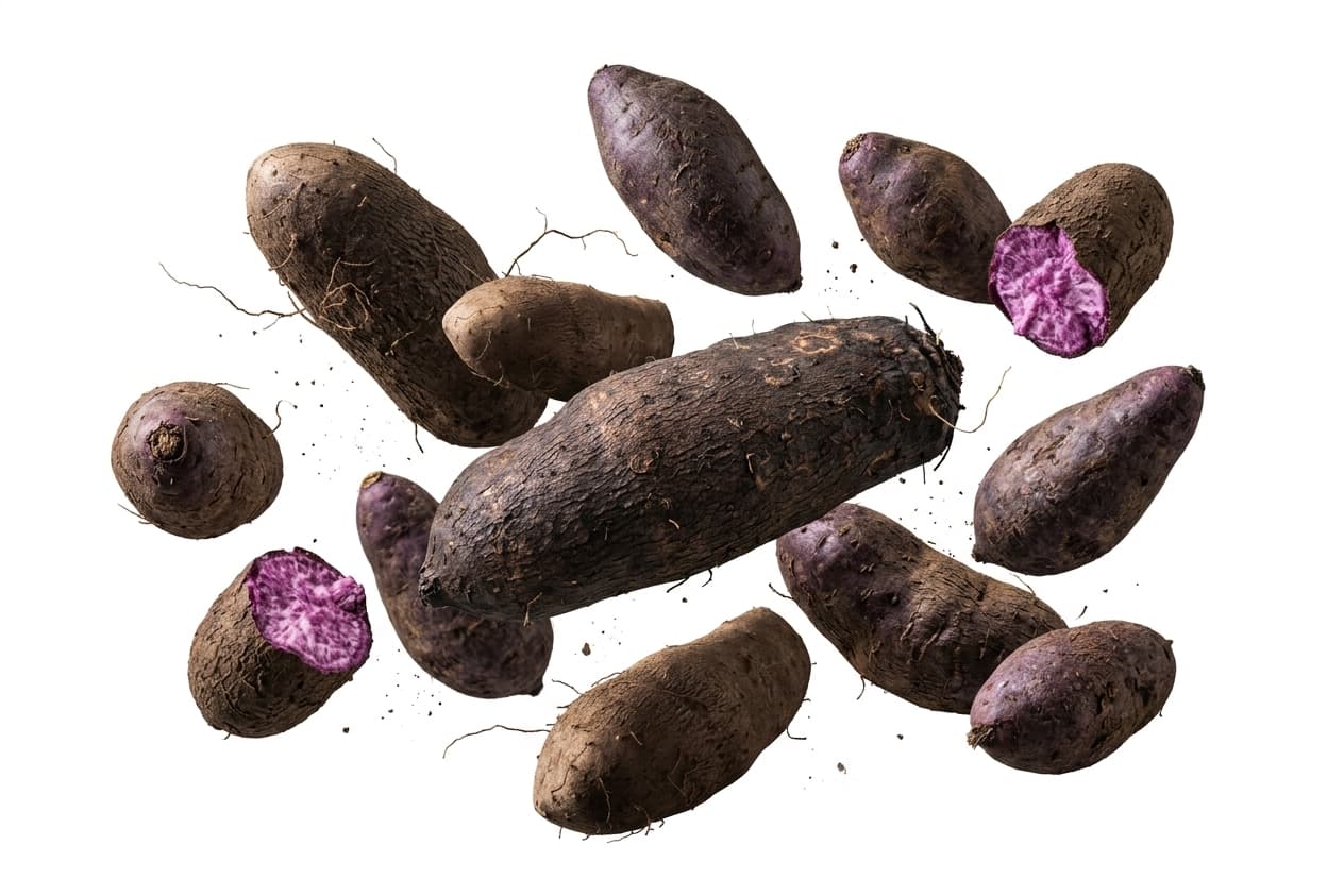 Whole purple yams, one cut to show the violet flesh